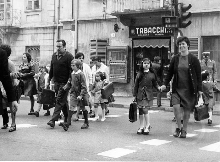 Bambini e adulti attraversano la strada per andare a scuola, Torino s.d. -  Archivio