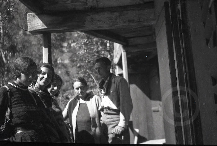 Foto di gruppo con uomini e donne sotto il porticato di un casa